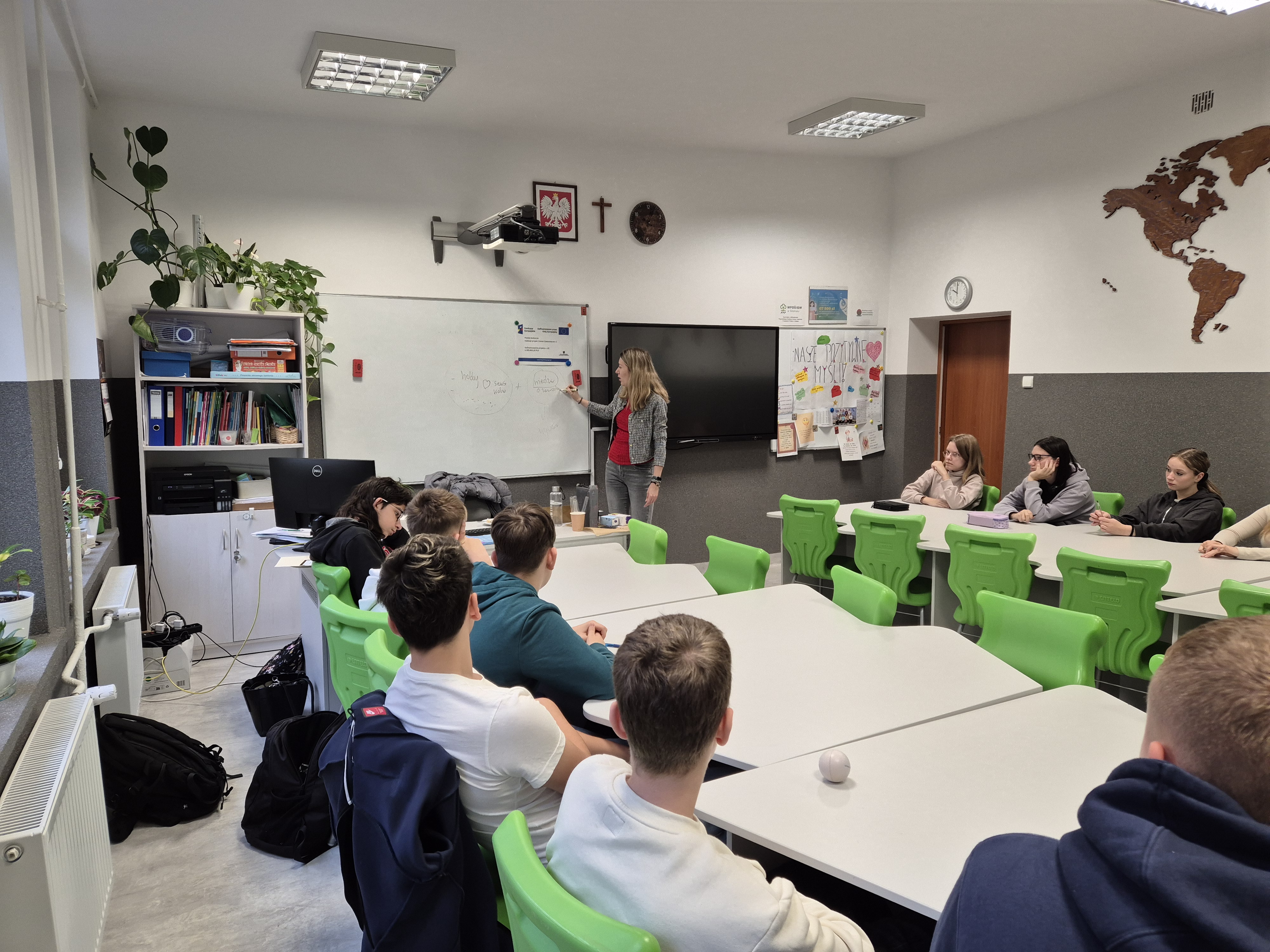 Zdjęcie przedstawia Koordynatorkę, która na tablicy spisuje ważne zagadnienia dotyczące  planowania kariery. W tym czasie uczniowie siedzą w ławkach i przedstawiają swoje zdanie