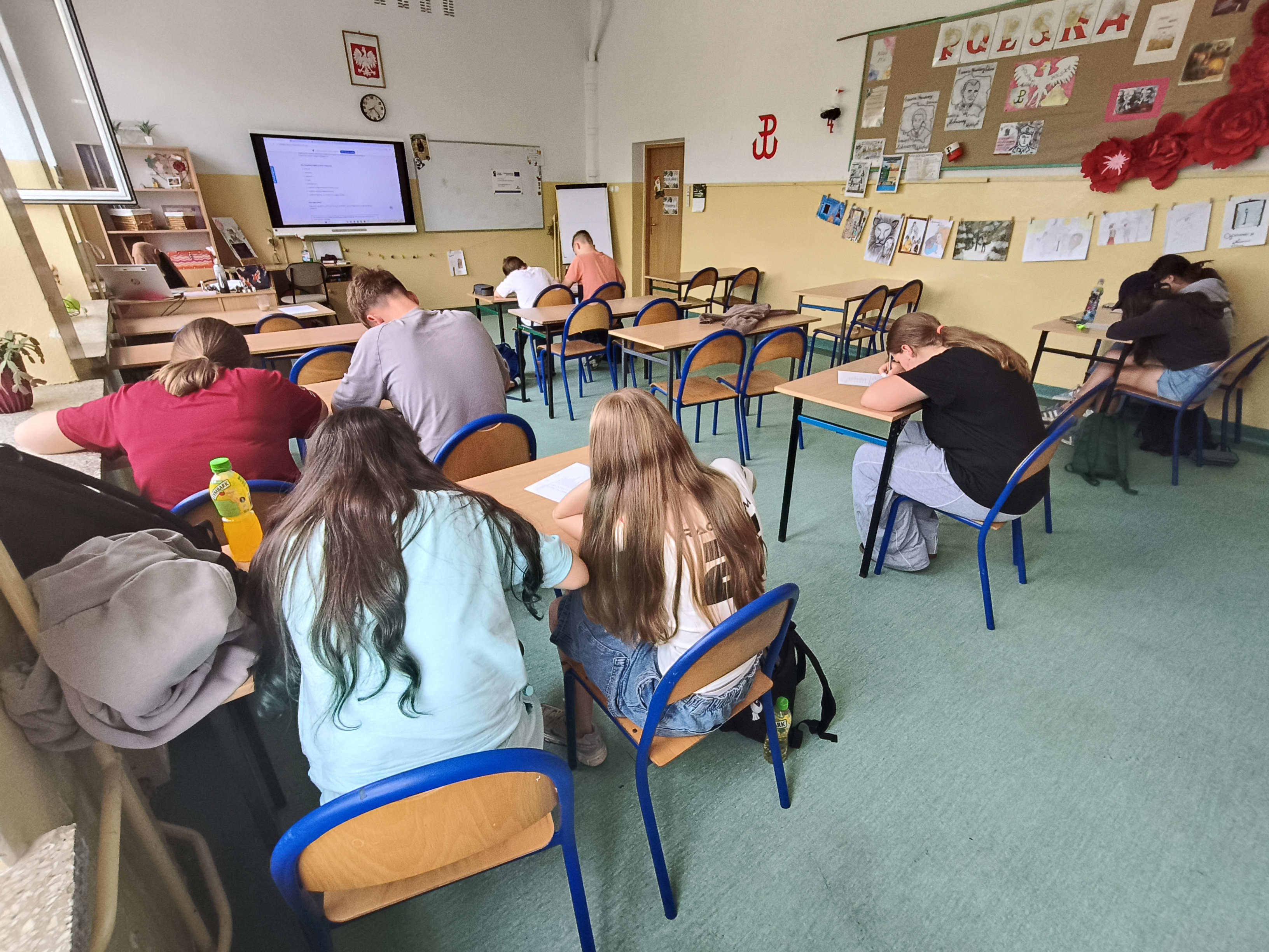 Zdjęcie przedstawia uczniów wykonujących ćwiczenie arkuszowe 